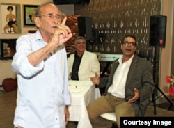 El poeta Orlando Fondevila mientras hace uso de la palabra, al fondo Armando de Armas, autor de la entrevista, y el también poeta Denis Fortún.