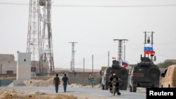Banderas rusas y sirias en una caravana militar cerca de Manbij. REUTERS/Omar Sanadiki