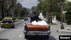 Recién casados en La Habana pasean a bordo de un "almendrón".