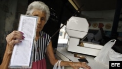 Una anciana muestra su libreta de racionamiento