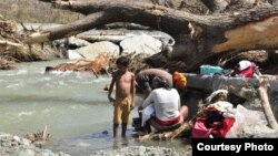 Residentes de Maisí lavando en el río después del paso del huracán Matthew (Venceremos).
