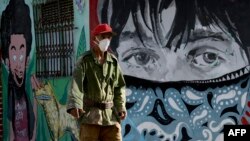 Un hombre se protege del coronavirus con una máscarilla en una calle de La Habana. (YAMIL LAGE / AFP)