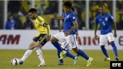El delantero colombiano Radamel Falcao (i) controla el balón junto al centrocampista brasileño Roberto Firmino (c).