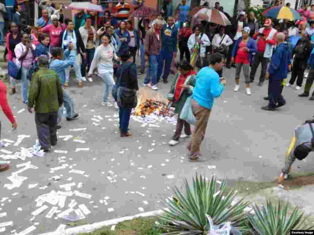 Las Brigadas de Respuesta Rápida queman ejemplares de la Declaración Universal de los Derechos Humanos, lanzados a la calle por las damas de Blanco. Foto cortesía Ángel Moya.
