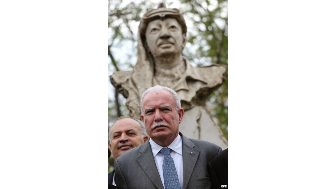Al-Malki junto al busto del fallecido líder palestino Yasser Arafat.