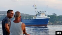 Dos pescadores en La Habana observan el barco estadounidense "Ana Cecilia", que zarpó desde Miami.