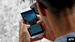 Un joven se conecta a Twitter desde su telefono en La Habana. (YAMIL LAGE / AFP)