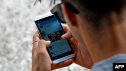 Un joven se conecta a Twitter desde su telefono en La Habana. (YAMIL LAGE / AFP)