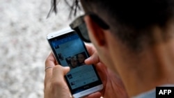 Un joven se conecta a Twitter desde su teléfono en La Habana. (YAMIL LAGE / AFP)