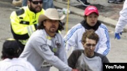 Jeff Bauman es evacuado en una silla de ruedas luego que una de las bombas en el maratón de Boston le segara las dos piernas.