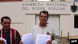 Oswaldo Payá (derecha) habla a la prensa frente a la Asamblea Nacional, el 18 de diciembre de 2007, tras entregar una carta solicitando una amnistía general para los presos políticos y libertad para salir y regresar al país para todos los cubanos. (AFP / Adalberto Roque).