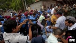 Un grupo de personas forcejea con un grupo de policías , a las afueras de la sede del Instituto Nicaragüense de Seguridad Social (INSS) en Managua, Nicaragua