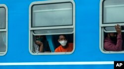 Pasajeros con mascarillas por el coronavirus viajan arriban a La Habana en un tren este jueves, 14 de enero. (AP/Ramon Espinosa)