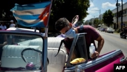 Cuentapropista desinfecta su carro en La Habana ante el coronavirus. (YAMIL LAGE / AFP)