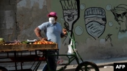 Un vendedor de vegetales en una calle de La Habana usa una máscara para protegerse del coronavirus, el 11 de abril de 2020. (Yamil Lage/AFP)