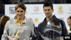 El tenista serbio Novak Djokovic (dcha) y el suizo Roger Federer posan para los fotógrafos tras la final del torneo de tenis de Dubái (Emiratos Árabes Unidos) disputada el sábado 26 de febrero de 2011.