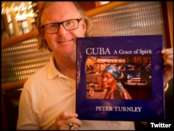 El fotógrafo Peter Turnley con su último libro publicado sobre Cuba.