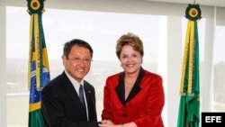 Fotografía cedida por la presidencia de Brasil donde se ve a la mandataria, Dilma Rousseff, posando junto al presidente mundial de Toyota, Akio Toyoda.