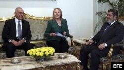 El presidente egipcio, Mohamed Morsi (der), se reúne con la secretaria de Estado de los Estados Unidos, Hillary Clinton (c), y el canciller egipcio, Mohamed Kamel Amr (izq). 