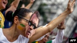 Una manifestante con una máscara de Bolsonaro apoya al candidato ultraderechista en Sao Paulo. 