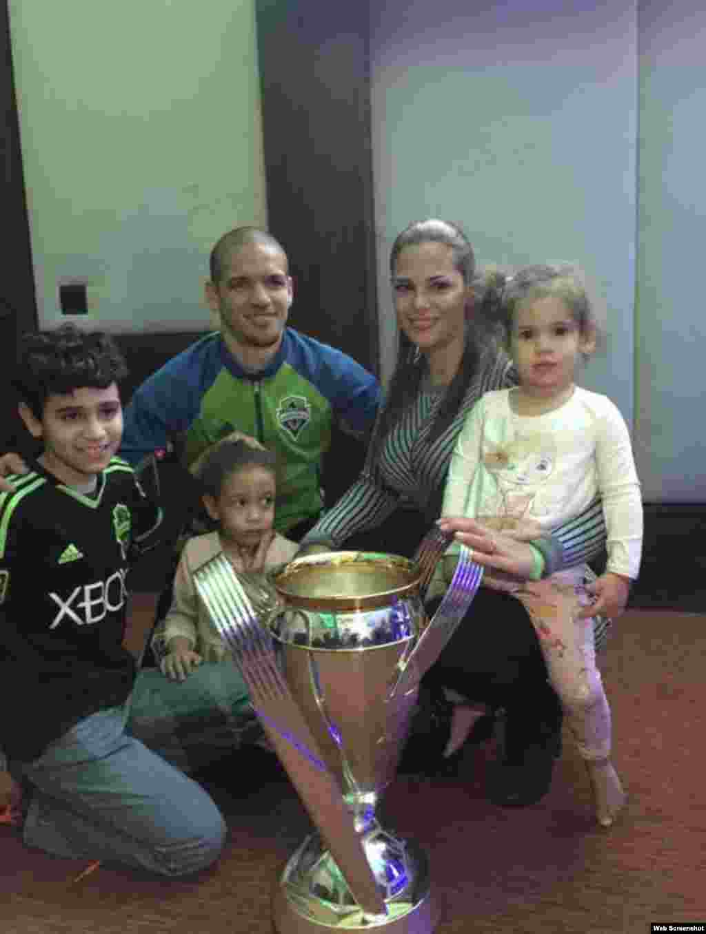 Osvaldo Alonso, su esposa e hijos junto al Trofeo Philip F. Anschutz.