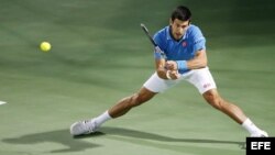El tenista serbio Novak Djokovic devuelve la bola.