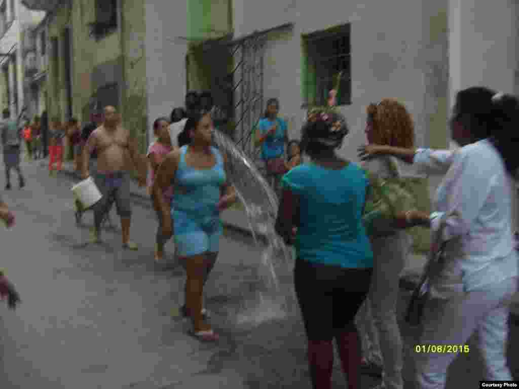 Una mujer, presunta dirigente de organización castrista, lanza agua a Damas de Blanco.