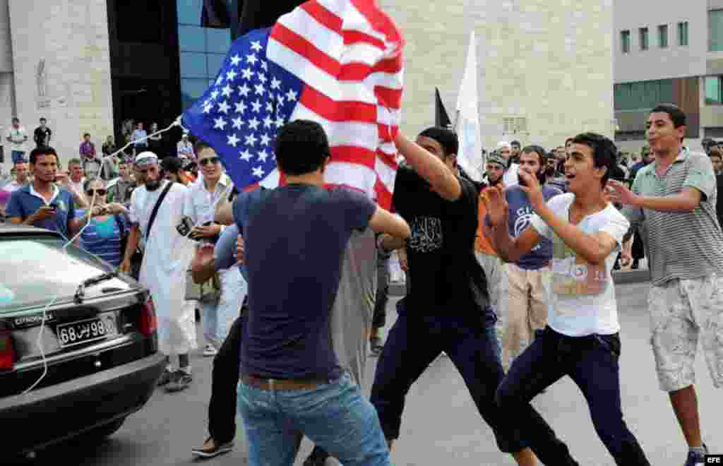 Unos manifestantes rompen una bandera estadounidense durante una concentración frente a la Embajada de Estados Unidos en Túnez (Túnez) en protesta contra un vídeo realizado por Sam Bacile, un israelí-estadounidense, en el que se critica el islam y se cari