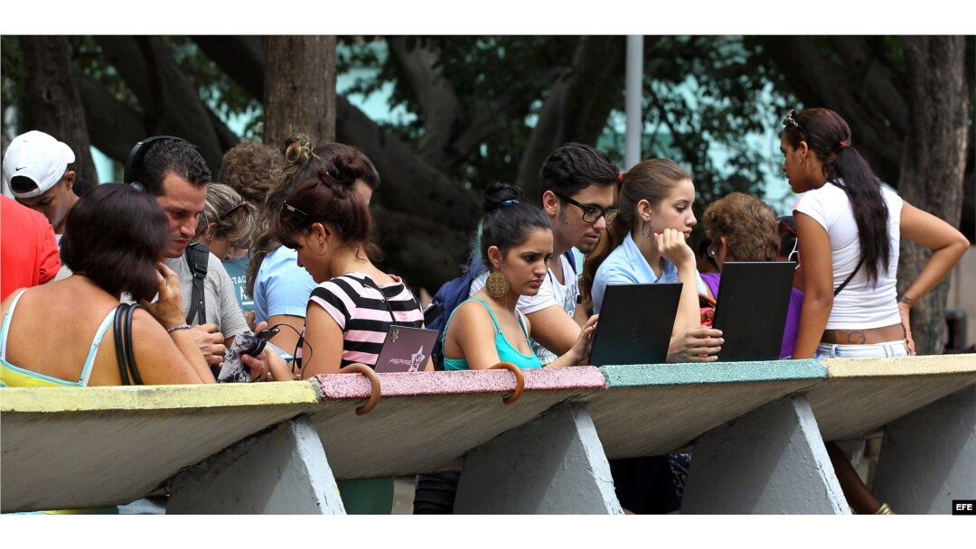 Varios jóvenes navegan por internet usando una red Wi Fi en La Habana.