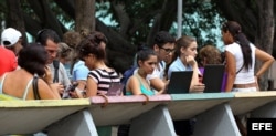 Varios jóvenes navegan por internet usando una red Wi Fi en La Habana.
