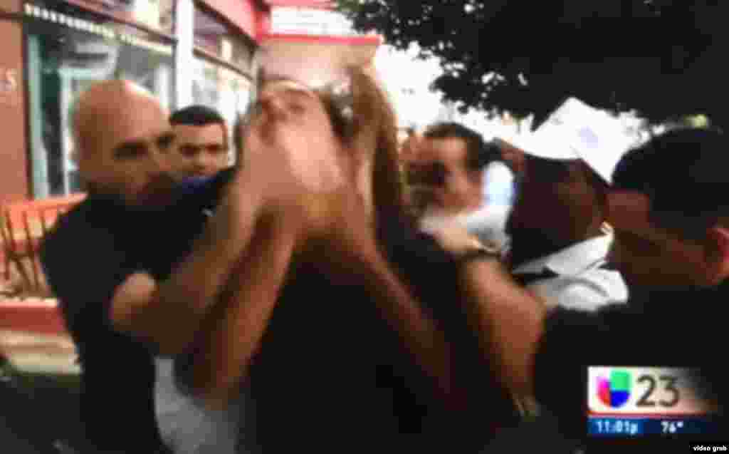 Agentes de civil tapan la boca del opositor cubano Lázaro Yuri Valle mientras grita "¡Vivan los derechos humanos!" (Univision)
