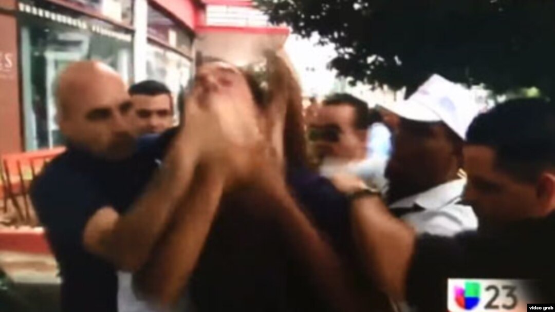 Agentes de civil tapan la boca del opositor cubano Lázaro Yuri Valle mientras grita "¡Vivan los derechos humanos!" (Univision)