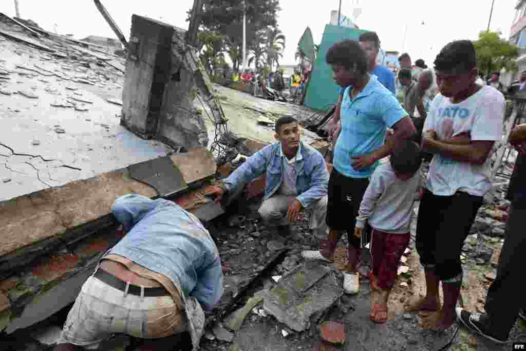  Los pobladores de Pedernales (Ecuador), afectados por el terremoto de 7,8 grados en la escala de Richter registrado el sábado en la costa norte de Ecuador, buscan entre las casas destruidas y los escombros. 