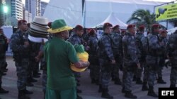Un vendedor observa a personal de seguridad formando durante la inauguración de la FIFA Fan Fest.