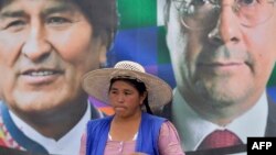 Trabajadora cocalera frente a pancarta de Morales y Arce en la región de Chapare