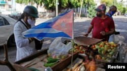 Un hombre compra vegetales en un puesto en La Habana.