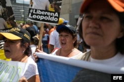 Seguidores del opositor venezolano Leopoldo López gritan consignas y se manifiestan con pancartas.