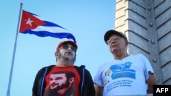 El comandante de la guerrilla de las FARC, Timoleón Jiménez, alias "Timochenko" (izq) y el comandante Rodrigo Granda asisten a un desfile militar en honor al fallecido dictador Fidel Castro, en La Habana.