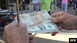 Un hombre muestra un peso convertible cubano y un dólar estadounidense. (Archivo)