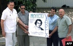 Hector Palacios (izq.) y Oswaldo Payá (2do der.), junto a otros disidentes, muestran una pancarta en alusión al proyecto Varela, momentos antes de su reunión con el ex presidente Jimmy Carter, en La Habana, el 16 de mayo de 2002.