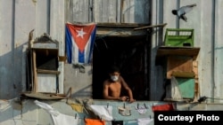 Un cubano observa la calle desde su balcón en La Habana, el 11 de abril de 2020. (Yamil Lage/AFP).