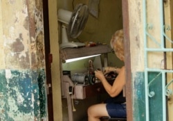 Una mujer trabaja en su taller de reparación de espejuelos, a la entrada d esu vivienda, en La Habana. (REUTERS/Desmond Boylan/Archivo)