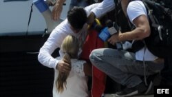 El dirigente opositor venezolano Leopoldo López da un abrazo a su espoza Lilian Tintori antes de entregarse a miembros de la Guardia Nacional (GNB)
