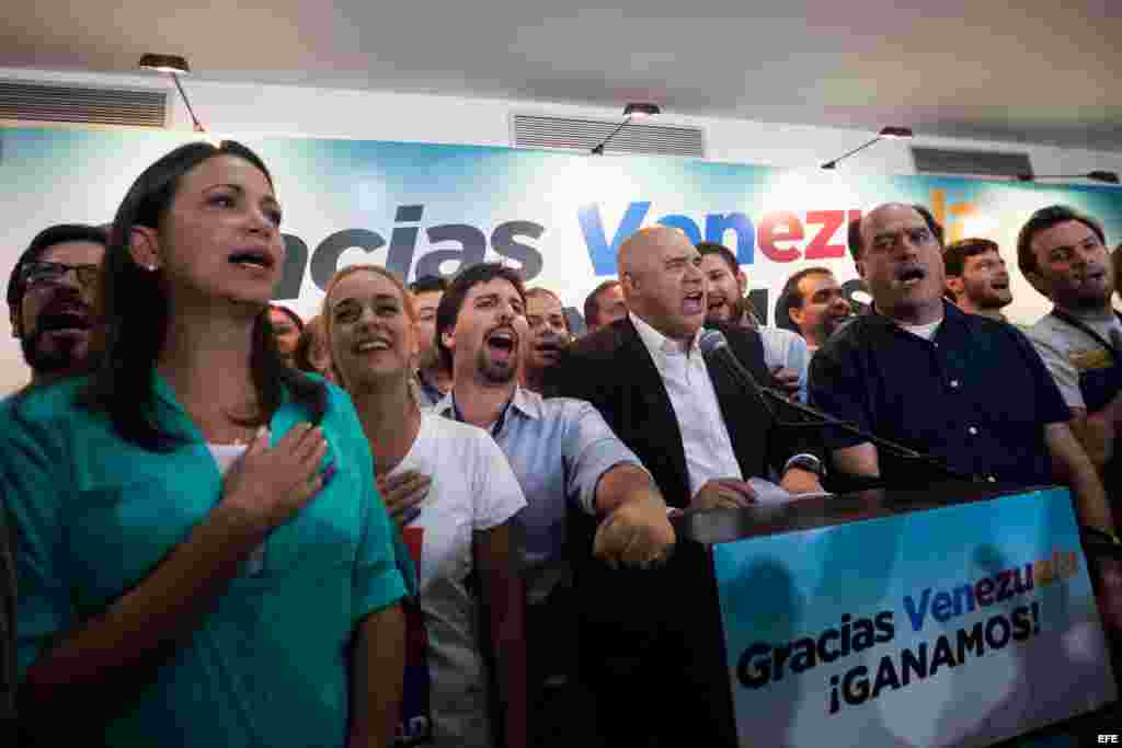 Miembros de la coalición opositora Mesa de Unidad Democrática (MUD) celebran la victoria el lunes 7 de diciembre de 2015, en la ciudad de Caracas (Venezuela). 