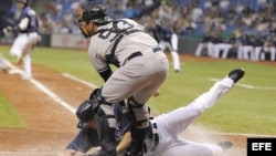 El jugador de Tampa Bay Matt Joyce (L) se desliza en el home frente al receptor de los Yankees de New York Austin Romine (R). 