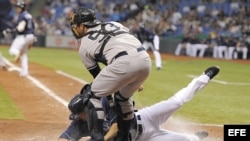 El jugador de Tampa Bay Matt Joyce (L) se desliza en el home frente al receptor de los Yankees de New York Austin Romine (R). Archivo.