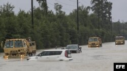Camiones de la Guardia Nacional de Texas que llevan a víctimas de inundaciones pasan junto a vehículos sumergidos después del paso del huracán Harvey en Houston, Texas, Estados Unidos, 29 de agosto de 2017. El huracán Harvey llegó a tierra en la costa sur