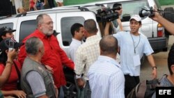 El periodista Mario Silva (con camisa roja) es asediado por la prensa tras estallar el escándalo.