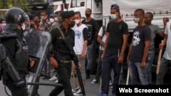 Jóvenes armados con garrotes obligados bajo amenaza a enfrentarse a los manifestantes en Cuba