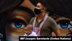 Un padre con su hijo durante la pandemia COVID en la comuna 13 de Medellin, en Colombia. IMF/Joaquín Sarmiento.